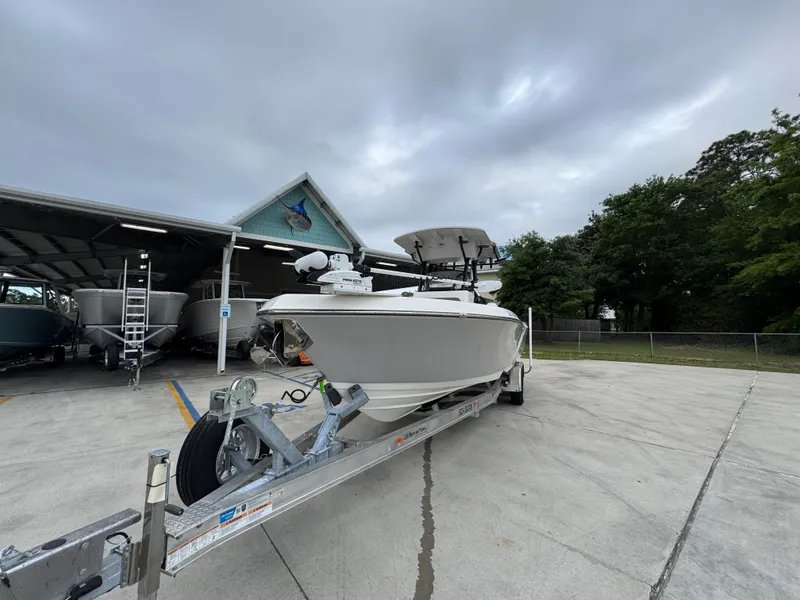 Slide: The Image of 2023 Sea Born LX26 Center Console boat on trailer, parked outdoors under cloudy sky. - 5