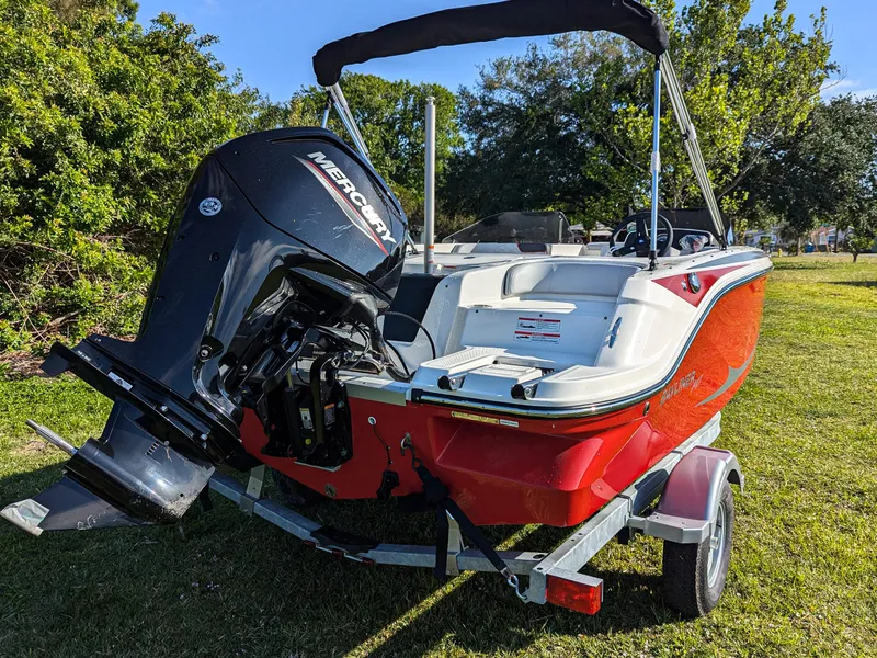 Slide: The Image of 2025 Bayliner Element M17 boat with Mercury engine on trailer, parked on grass. - 6