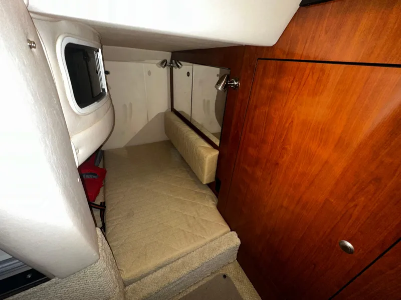 Slide: The Image of 2006 Sea Ray 280 Sundancer cabin interior with wood paneling and cozy sleeping area. - 10