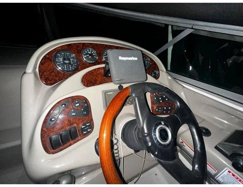 Slide: The Image of Helm of 2006 Sea Ray 280 Sundancer with Raymarine navigation system and wood-accented dashboard. - 13