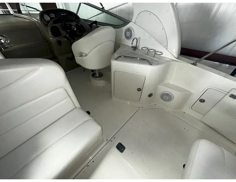 Slide: The Image of 2006 Sea Ray 280 Sundancer interior with white seating and helm area. - 2