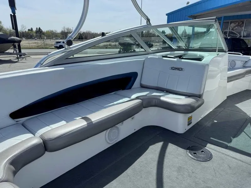 Slide: The Image of 2004 MasterCraft X30 boat interior with white and gray seating, glass windshield, and outdoor setting. - 10