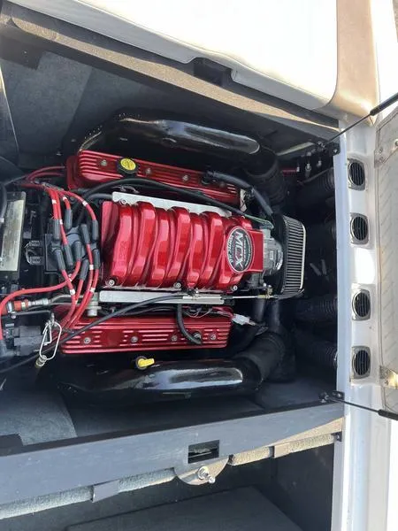 Slide: The Image of 2004 MasterCraft X30 engine with red components and black hoses in open compartment. - 17