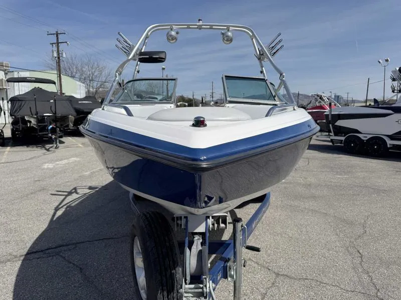 Slide: The Image of 2004 MasterCraft X30 boat on trailer, front view, in a parking lot. - 2