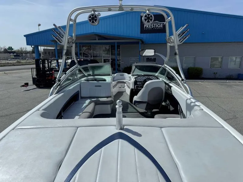Slide: The Image of 2004 MasterCraft X30 boat with tower speakers, parked outside a blue building. - 9