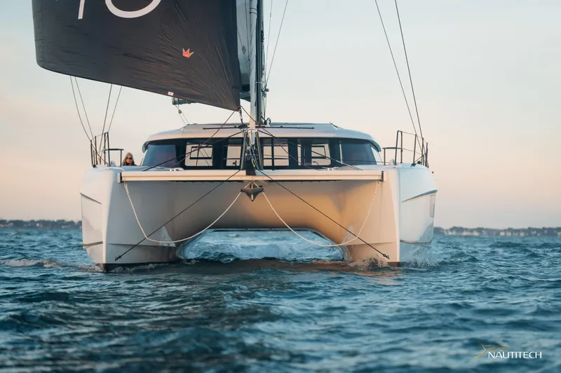 Slide: The Image of 2025 Nautitech 48 Open catamaran sailing on open water at sunset. - 5