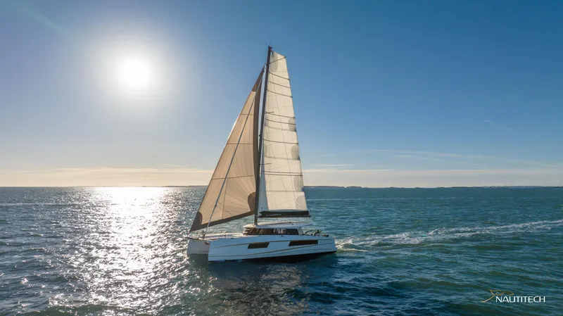 Slide: The Image of Sailing catamaran Nautitech 48 Open 2025 gliding on sunlit ocean waters. - 9