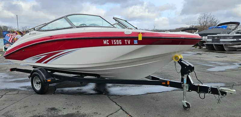 Slide: The Image of 2015 Yamaha Boats SX190 on trailer, red and white design, parked outdoors. - 1