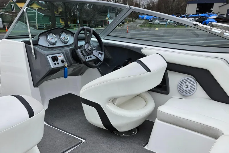 Slide: The Image of 2015 Yamaha Boats SX190 interior with white seating and dashboard controls. - 12