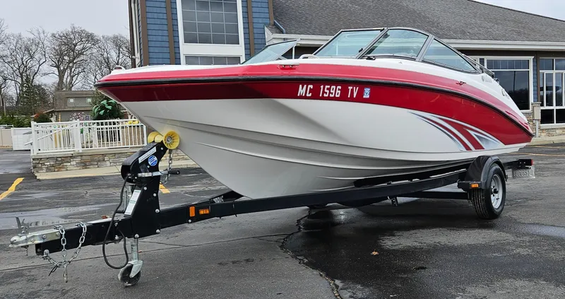 Slide: The Image of 2015 Yamaha Boats SX190 on trailer, red and white design, parked outdoors. - 5