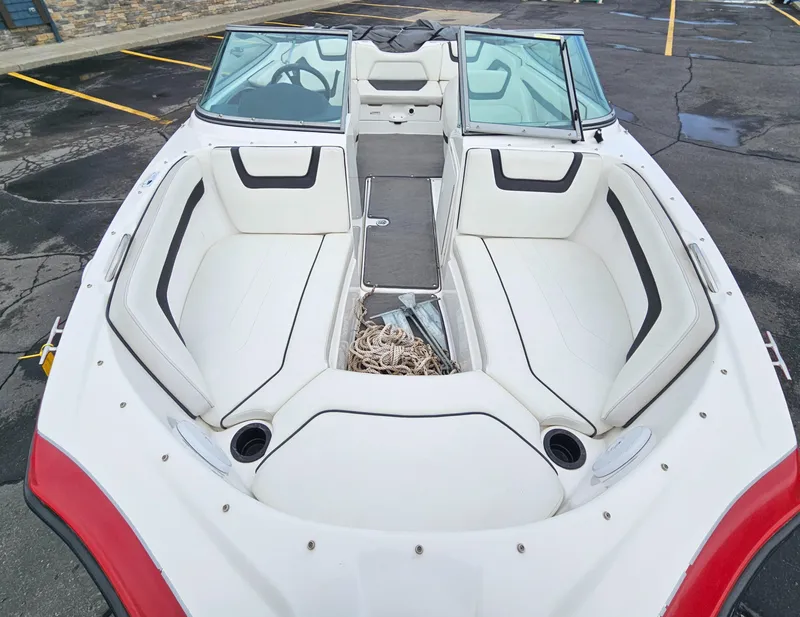 Slide: The Image of 2015 Yamaha Boats SX190 interior with white seating and windshield in a parking lot. - 7