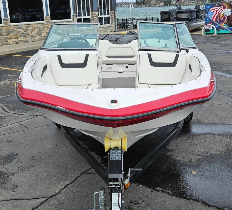 Slide: The Image of 2015 Yamaha Boats SX190 on trailer, front view, parked near waterfront. - 8