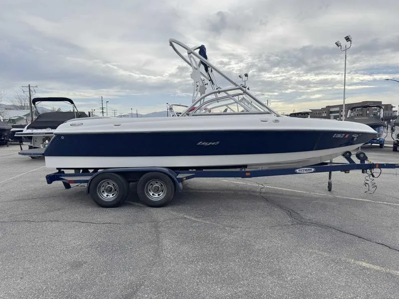 Slide: The Image of 2006 Tigé 22V boat on trailer in parking lot, overcast sky. - 2