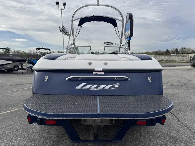 Slide: The Image of 2006 Tigé 22V boat, rear view, parked in a lot under cloudy sky. - 5