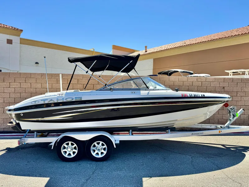 Slide: The Image of 2011 Tahoe Q8 SSi boat on trailer, black and white design, parked outdoors. - 0