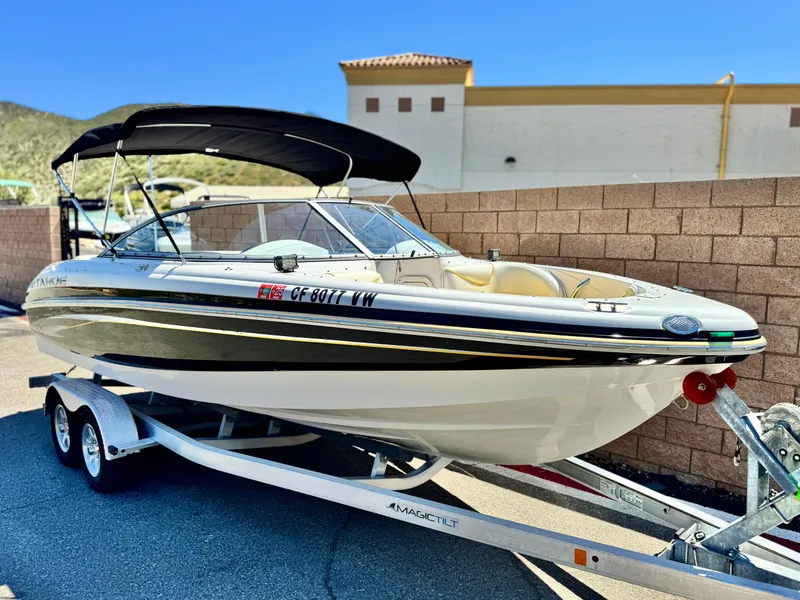 Slide: The Image of 2011 Tahoe Q8 SSi boat on trailer, parked outdoors, with canopy and sleek design. - 1