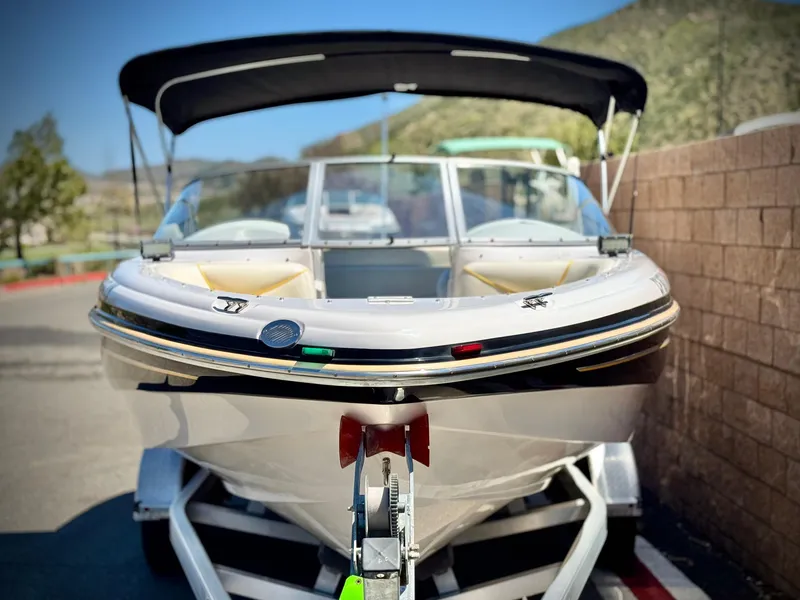 Slide: The Image of 2011 Tahoe Q8 SSi boat on trailer, parked outdoors with canopy. - 2