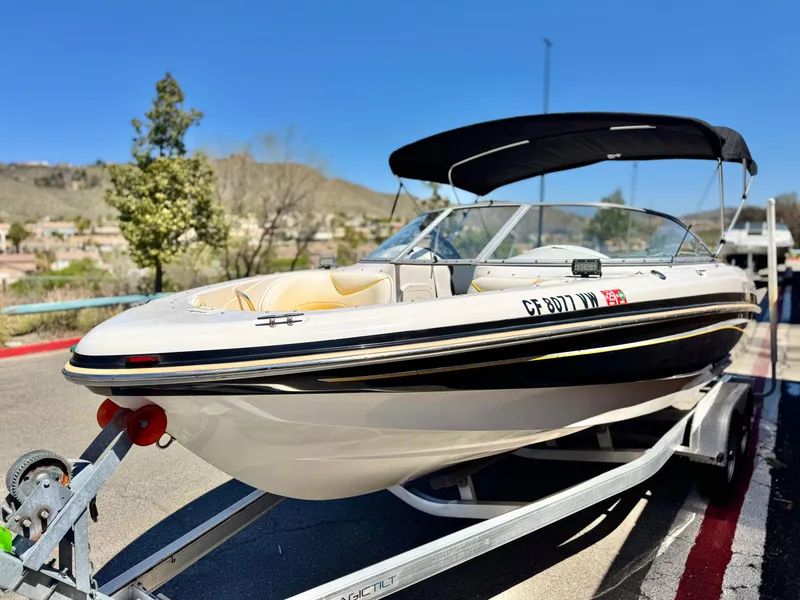 Slide: The Image of 2011 Tahoe Q8 SSi boat on trailer, parked outdoors under clear blue sky. - 3