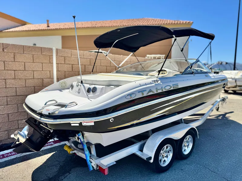 Slide: The Image of 2011 Tahoe Q8 SSi boat on trailer, black and white design, parked outdoors. - 5