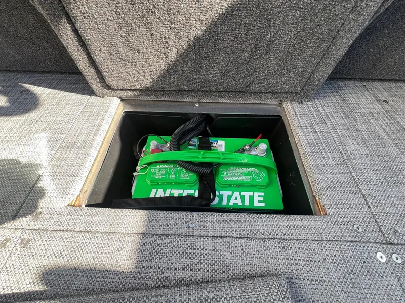 Slide: The Image of 2019 Alumacraft Trophy 175 boat battery compartment with green Interstate battery. - 17