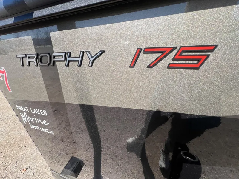 Slide: The Image of 2019 Alumacraft Trophy 175 boat side view with logo and dealership details. - 2
