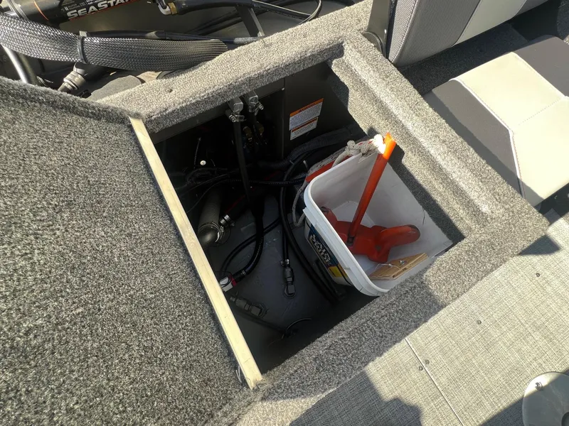 Slide: The Image of Open storage compartment in 2019 Alumacraft Trophy 175 boat, showing tools and equipment. - 29