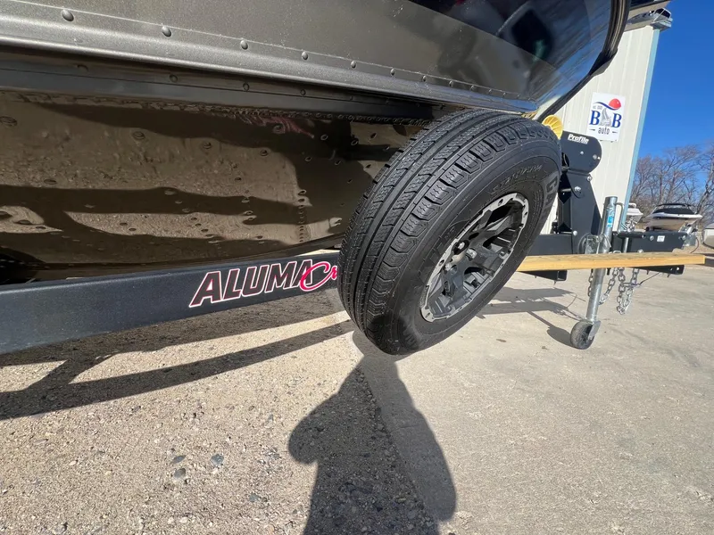 Slide: The Image of 2019 Alumacraft Trophy 175 boat trailer with visible tire and branding. - 35