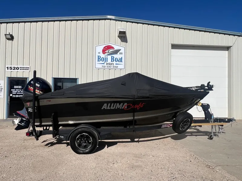 Slide: The Image of 2019 Alumacraft Trophy 175 boat with cover, parked outside Boji Boat building. - 37