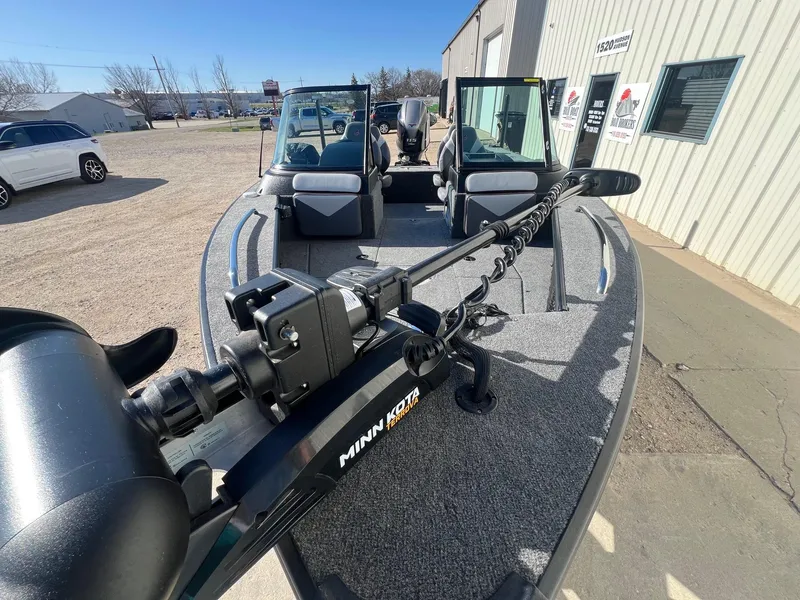 Slide: The Image of 2019 Alumacraft Trophy 175 boat with Minn Kota trolling motor, parked outside a building. - 6