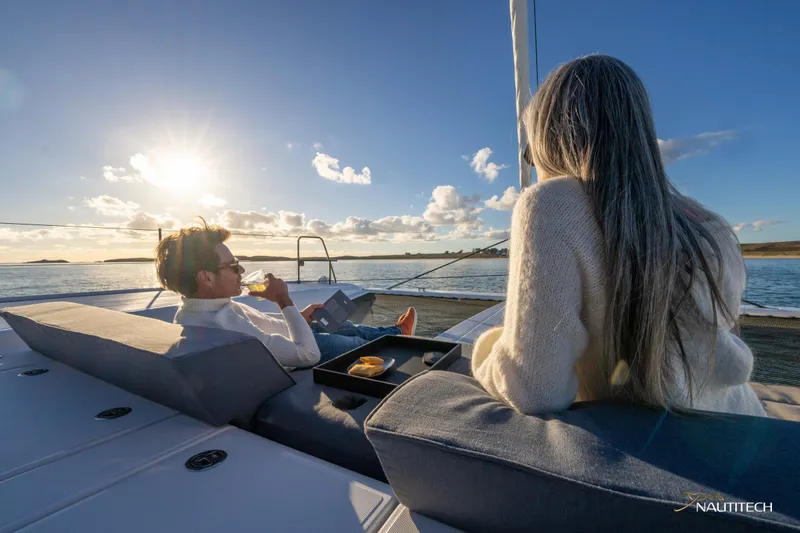 Slide: The Image of Couple relaxing on Nautitech 48 Open yacht, enjoying sunset on the water, 2025 model. - 20