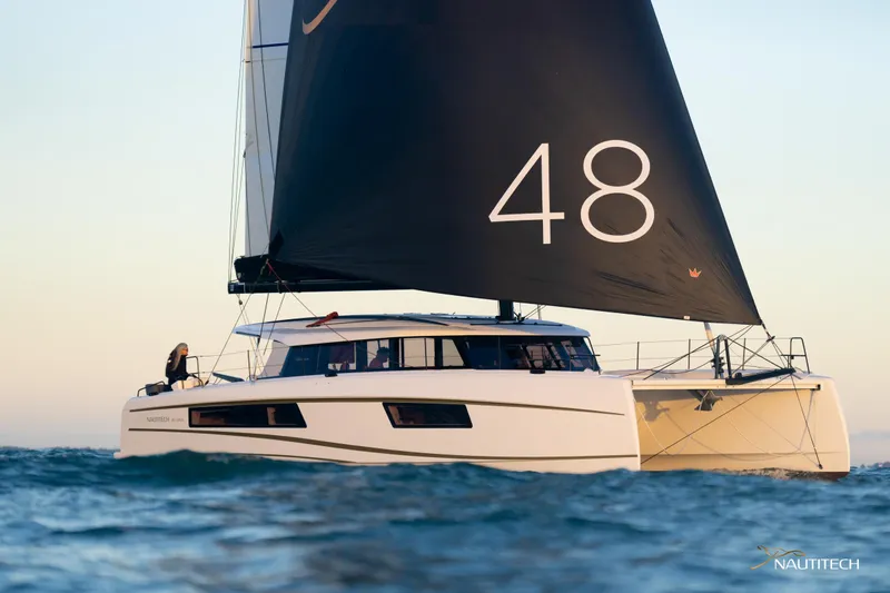 Slide: The Image of 2025 Nautitech 48 Open catamaran sailing on open water, featuring sleek design and large sail. - 3