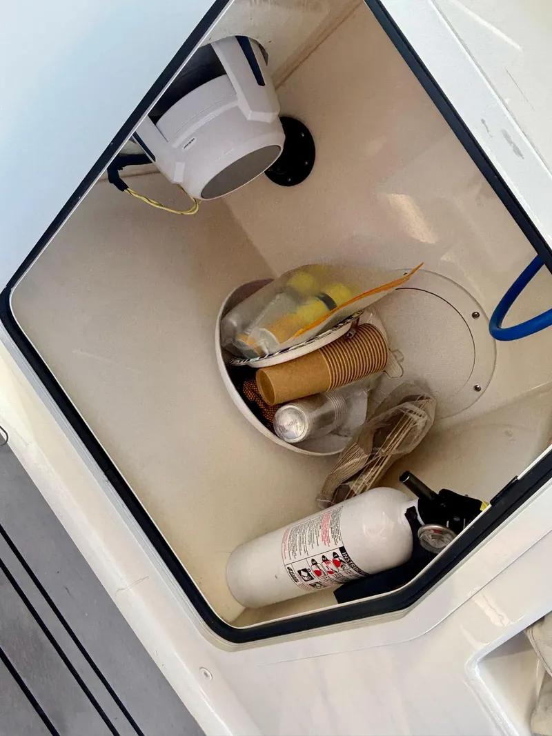 Slide: The Image of Storage compartment in a 2020 Boston Whaler 280 Vantage with fire extinguisher and supplies. - 10
