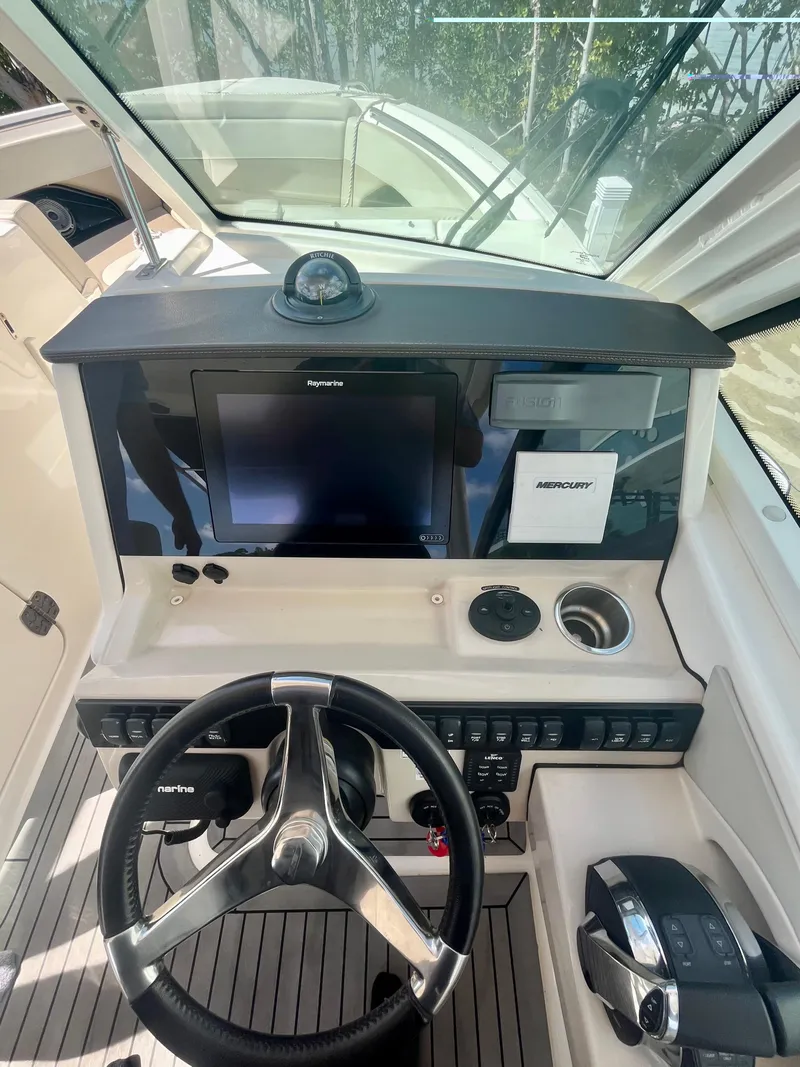 Slide: The Image of 2020 Boston Whaler 280 Vantage boat dashboard with steering wheel and navigation controls. - 5