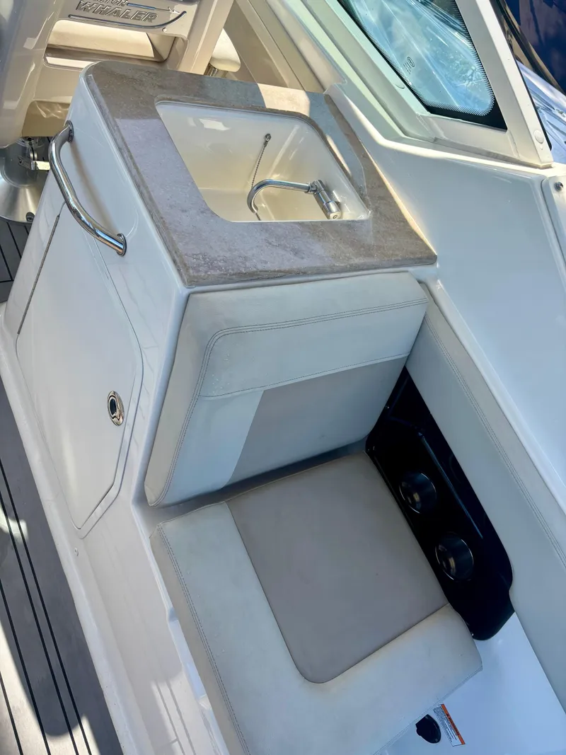 Slide: The Image of 2020 Boston Whaler 280 Vantage boat interior with sink and seating area. - 7