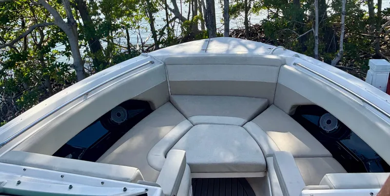 Slide: The Image of 2020 Boston Whaler 280 Vantage boat interior with cushioned seating and scenic background. - 8