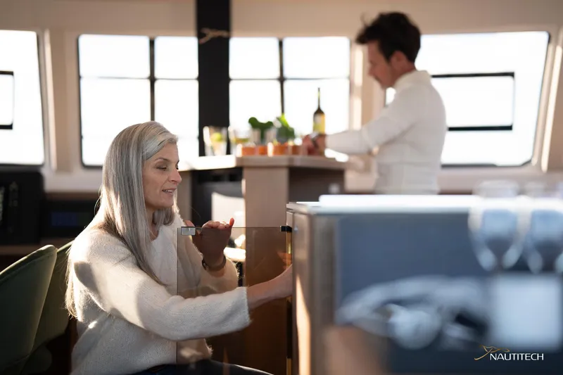 Slide: The Image of Two people enjoying the interior of a 2025 Nautitech 48 Open yacht. - 41