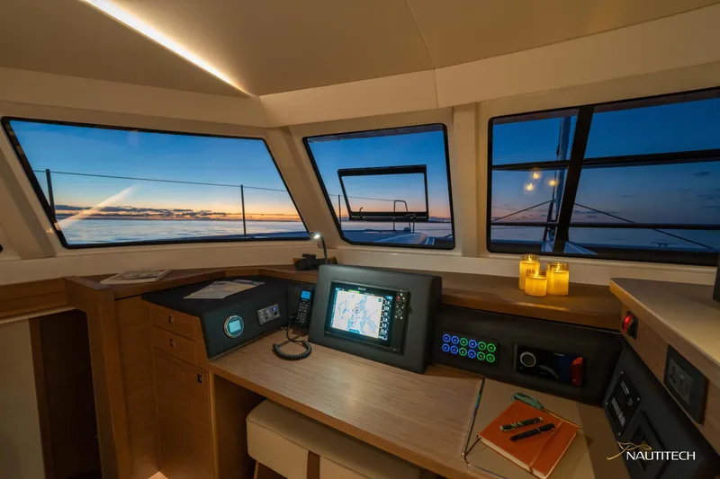 Slide: The Image of Nautitech 48 Open 2025 yacht interior with navigation equipment and ocean view at sunset. - 43