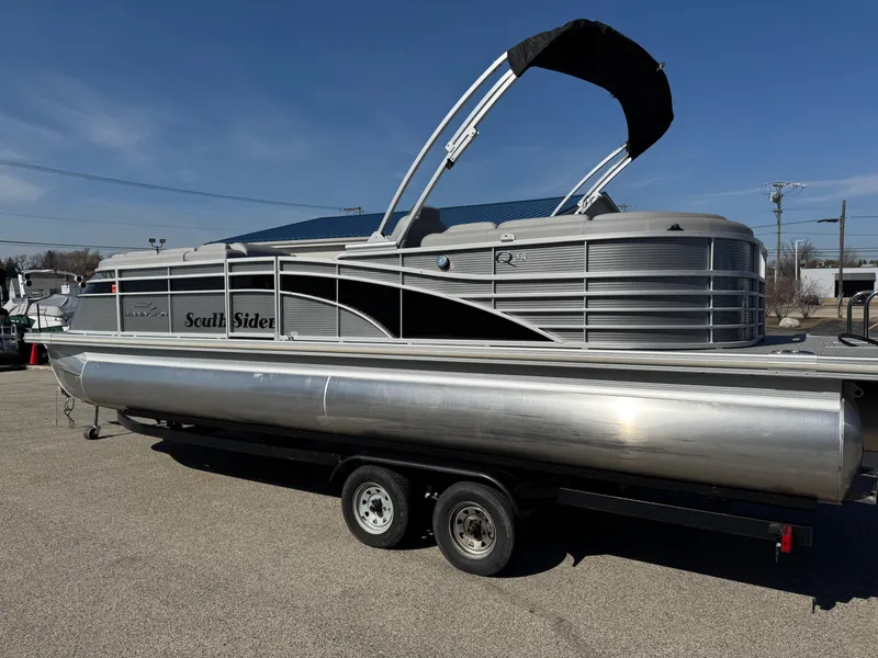 Slide: The Image of 2019 Bennington R 25 RSR pontoon boat on trailer, silver exterior, black canopy. - 6
