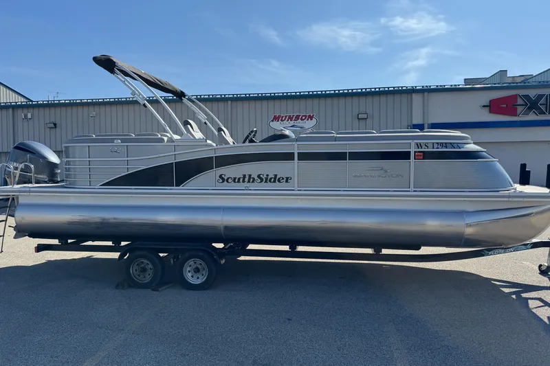 Slide: The Image of 2019 Bennington R 25 RSR pontoon boat on trailer, parked outside a building. - 8
