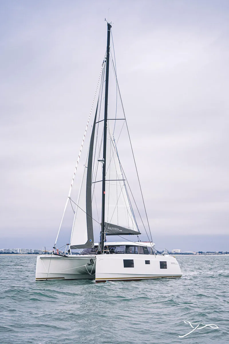 Slide: The Image of 2025 Nautitech 40 Open catamaran sailing on calm waters under a cloudy sky. - 0