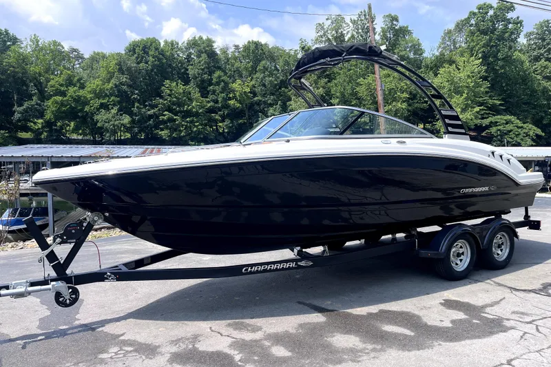 The Image of 2025 Chaparral 230 SSi boat on trailer, parked outdoors with trees in background. - 0