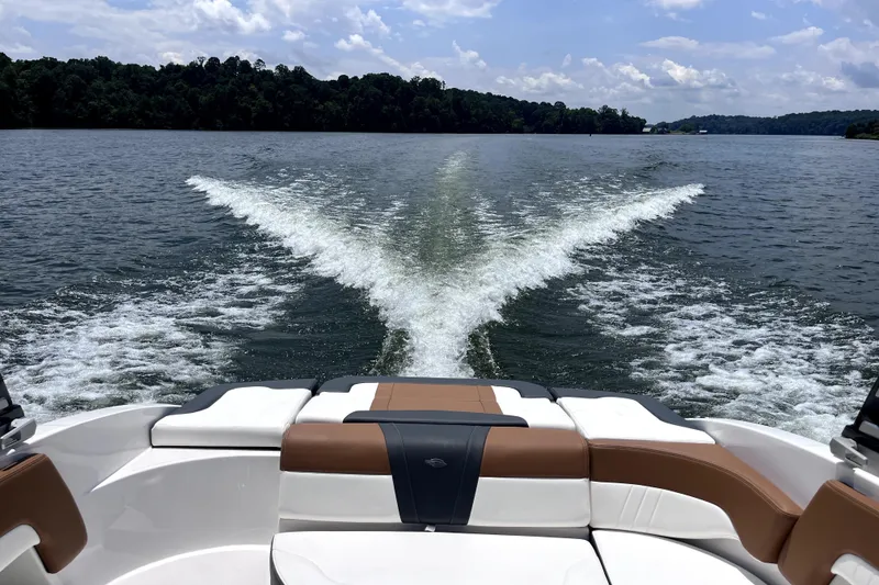 Slide: The Image of 2025 Chaparral 230 SSi boat cruising on a scenic lake, leaving a wake trail. - 10