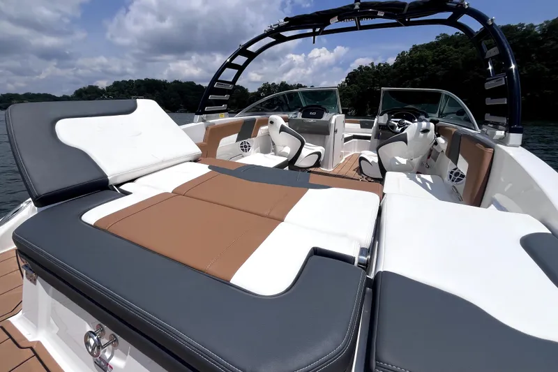 Slide: The Image of 2025 Chaparral 230 SSi boat interior with luxurious seating and sleek design on a sunny day. - 13