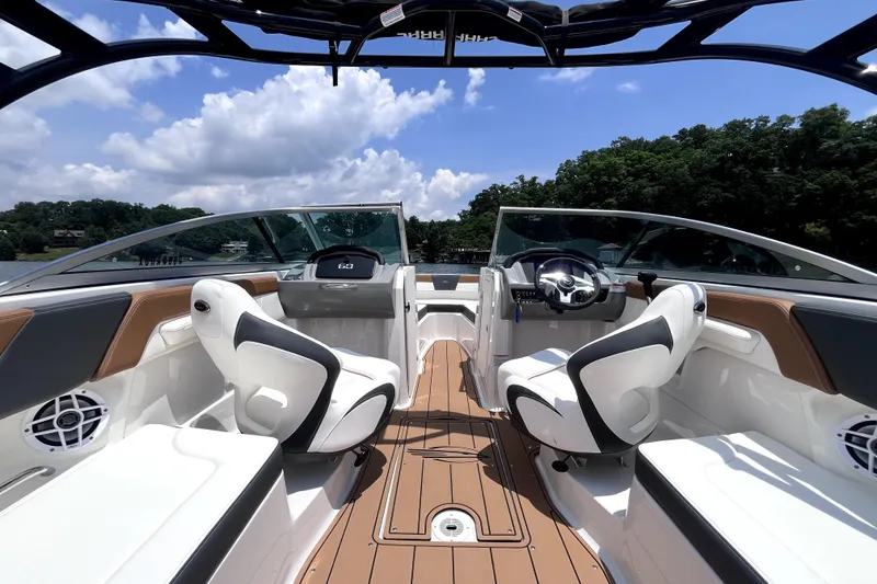 Slide: The Image of 2025 Chaparral 230 SSi boat interior with sleek seating and modern dashboard on a sunny day. - 3