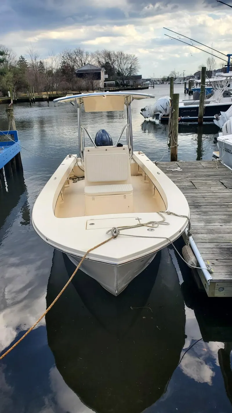 Slide: The Image of 2025 Jones Brothers 23 Cape Fisherman boat docked on a calm river. - 4