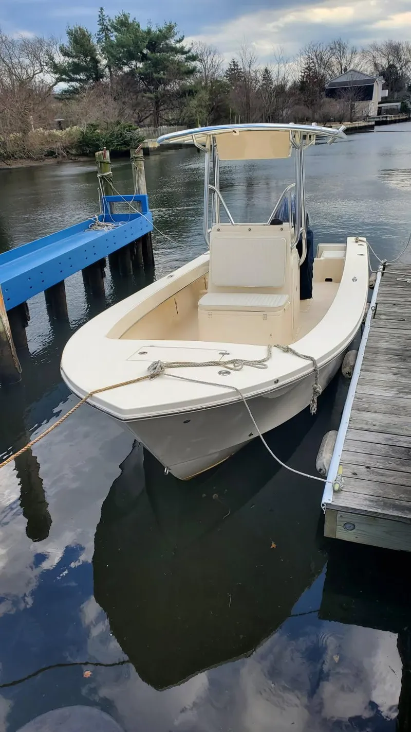 Slide: The Image of 2025 Jones Brothers 23 Cape Fisherman boat docked on a calm river. - 18