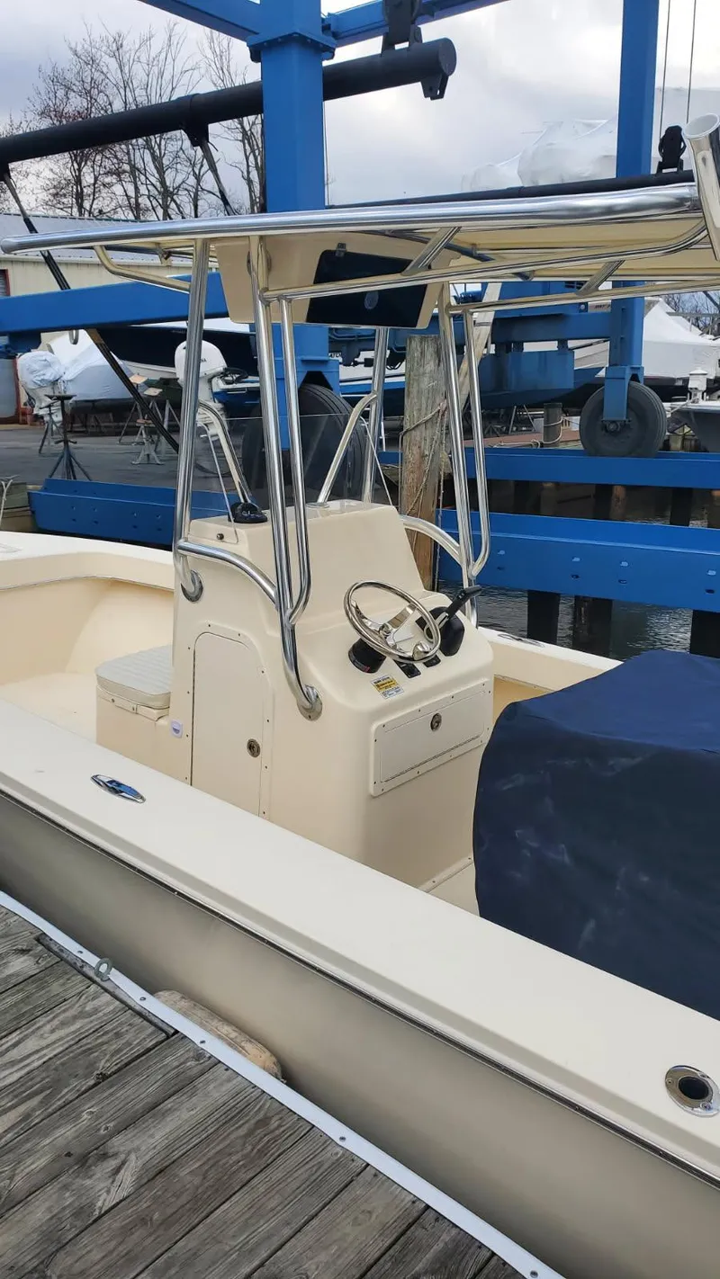 Slide: The Image of 2025 Jones Brothers 23 Cape Fisherman boat docked, featuring center console and T-top. - 5