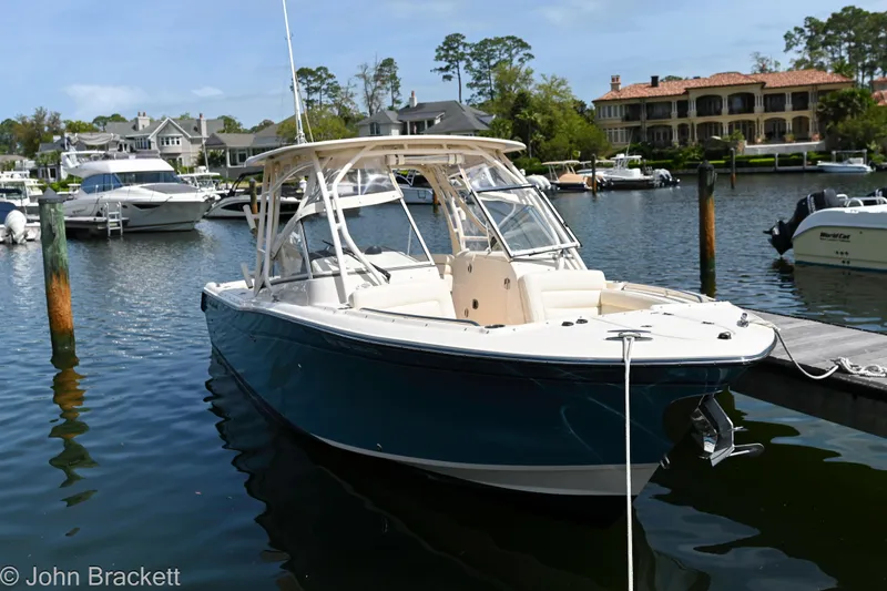 Slide: The Image of 2019 Grady-White Freedom 275 boat docked in a scenic marina setting. - 14