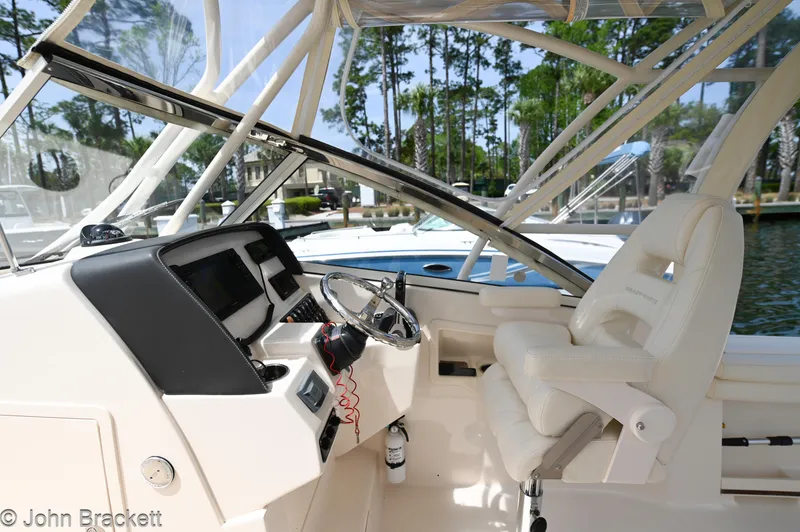 Slide: The Image of 2019 Grady-White Freedom 275 boat interior with steering wheel and seating. - 23