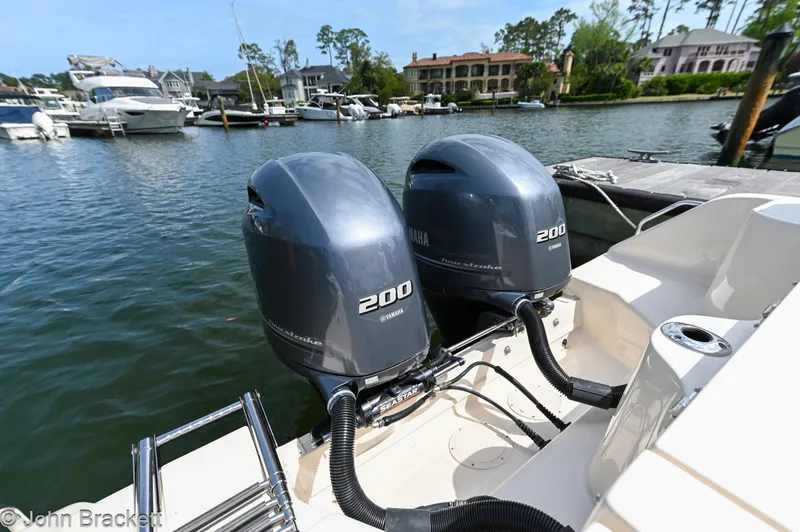Slide: The Image of Twin Yamaha 200 engines on a 2019 Grady-White Freedom 275 boat docked by waterfront homes. - 33